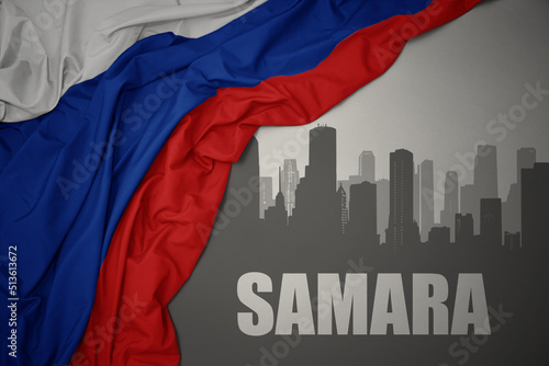 Quadro su tela abstract silhouette of the city with text Samara near waving national flag of russia on a gray background