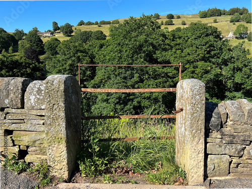 Rusty old metal gate, leading into the fields, with trees, and hills in the distance on, Dean House Lane, Midgley, Halifax, UK photo