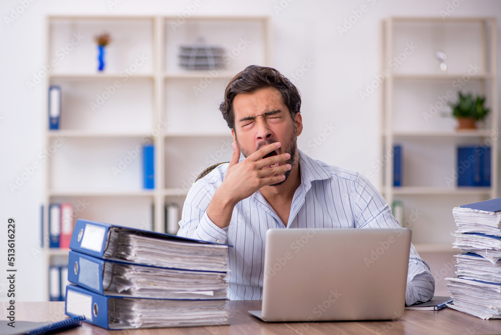 Naklejka premium Young male employee unhappy with excessive work in the office