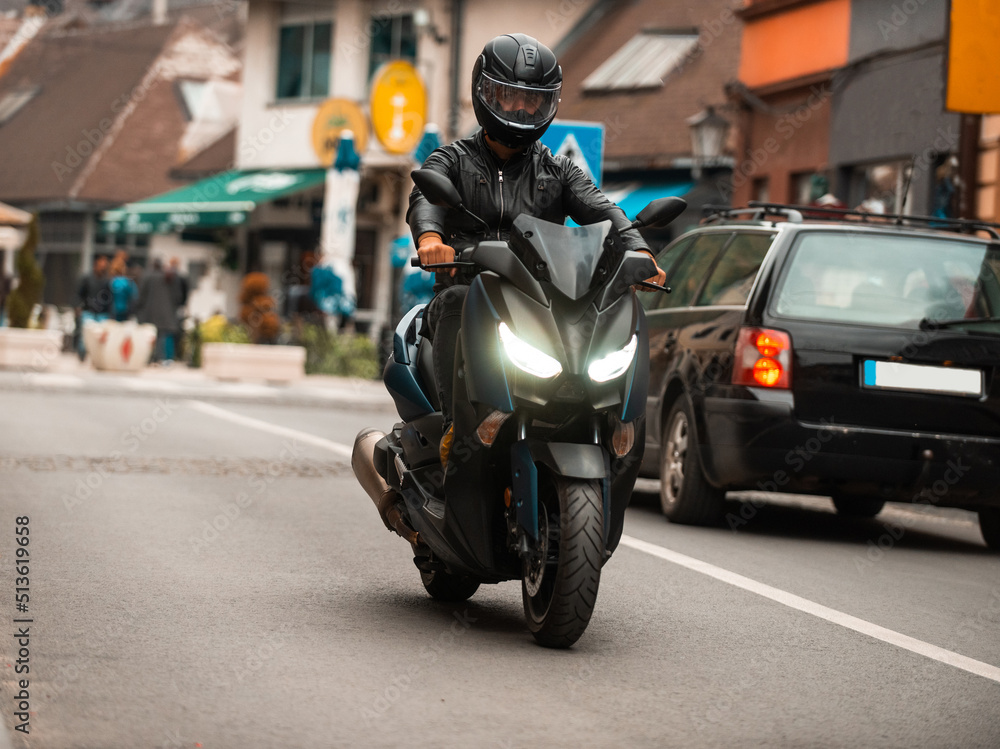 A modern motorcyclist drives on a motorcycle on the road in the city. A modern motorcyclist drives on a motorcycle on the road in the city.