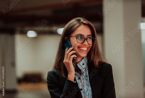 An attractive business woman in glasses using a smartphone.