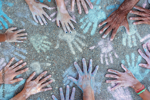 Coloured chalk powder hands of people painting their colored hand prints on the playground photo