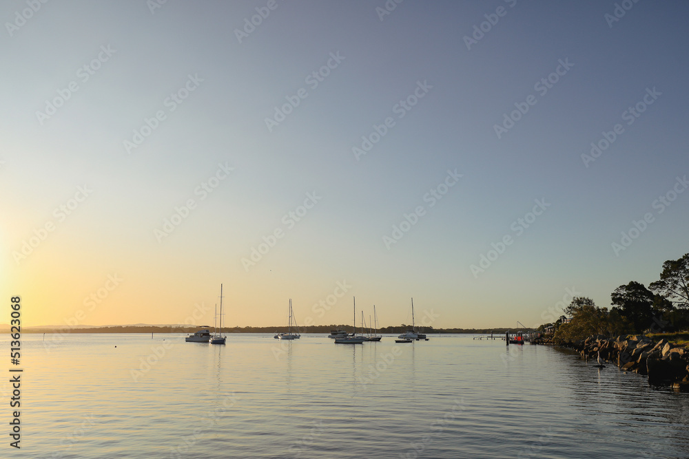 Yachts moored on the Clarence River at sunset. Iluka NSW Australia