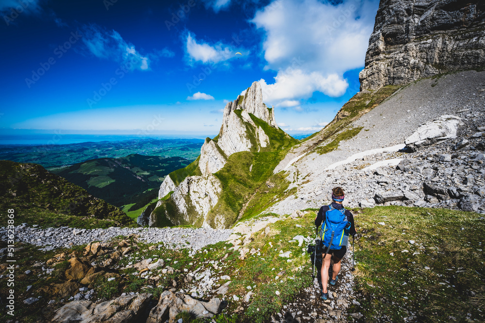 Fototapeta premium Hiker is descending on trail with a beautiful panorama