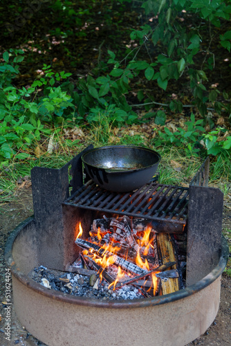 Ruddy tasty potato is frying in a cauldron in oil on nature on fire, closeup view. High-quality photo