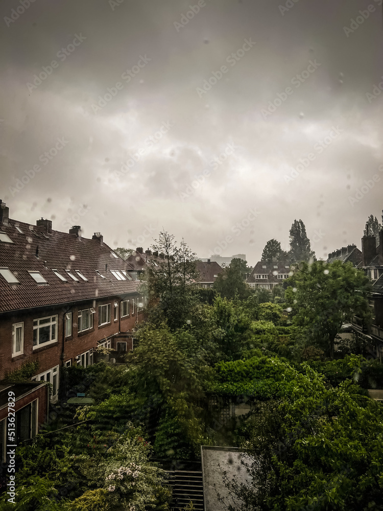 Beautiful cityscape with residential buildings on rainy day, view from window