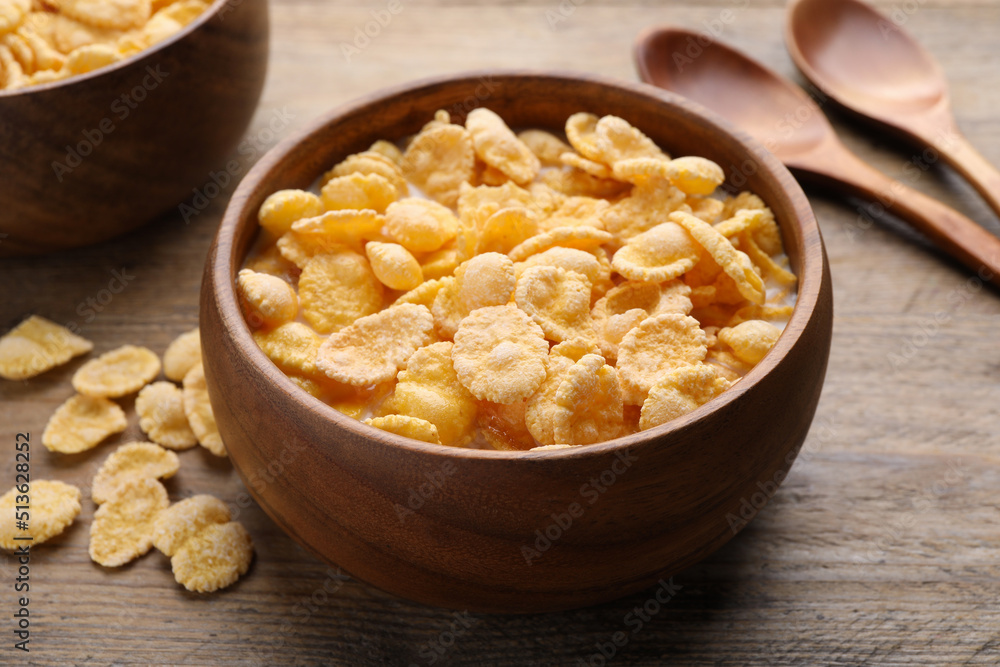 Tasty cornflakes with milk served on wooden table, closeup Tasty cornflakes with milk served on wooden table, closeup
