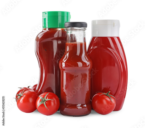 Different bottles of tasty ketchup and fresh tomatoes isolated on white