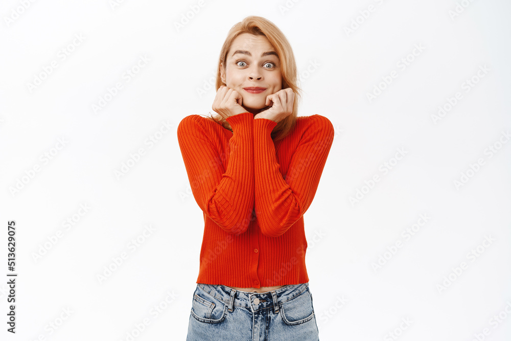Excited young woman anticipating, looking at something with fascinated, admiring face expression, standing over white background Excited young woman anticipating, looking at something with fascinated, admiring face expression, standing over white background