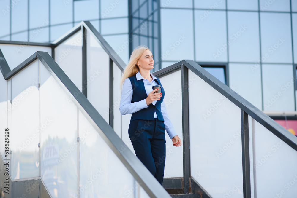 Beautiful Woman Going To Work With Coffee Walking Near Office Building. Portrait Of Successful Business Woman Holding Cup Of Hot Drink. Beautiful Woman Going To Work With Coffee Walking Near Office Building. Portrait Of Successful Business Woman Holding Cup Of Hot Drink.