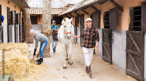 Foto Stable courtyard - horse walking and tidying up