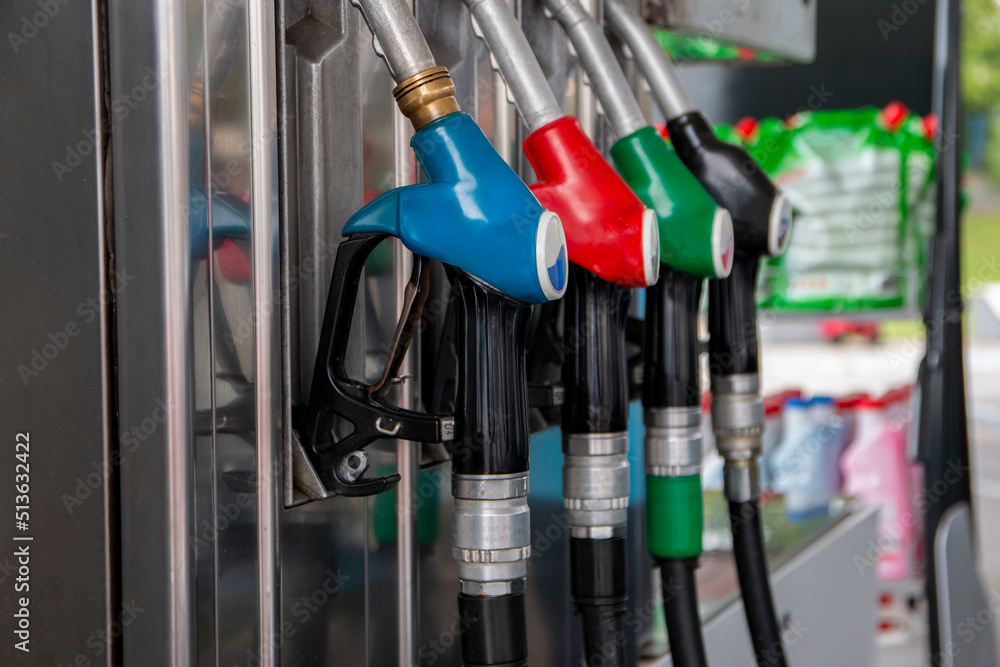 Petrol pump filling nozzles at gas station. Blue, red, green, black color fuel gasoline dispenser background Petrol pump filling nozzles at gas station. Blue, red, green, black color fuel gasoline dispenser background