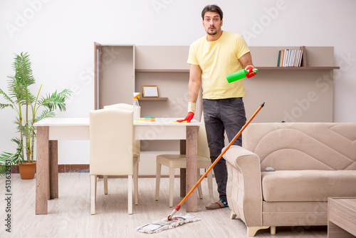 Young male contractor cleaning the house