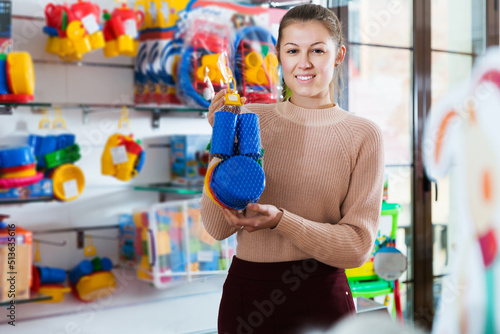 smiling young consumer with children's plastic toys in the kids store