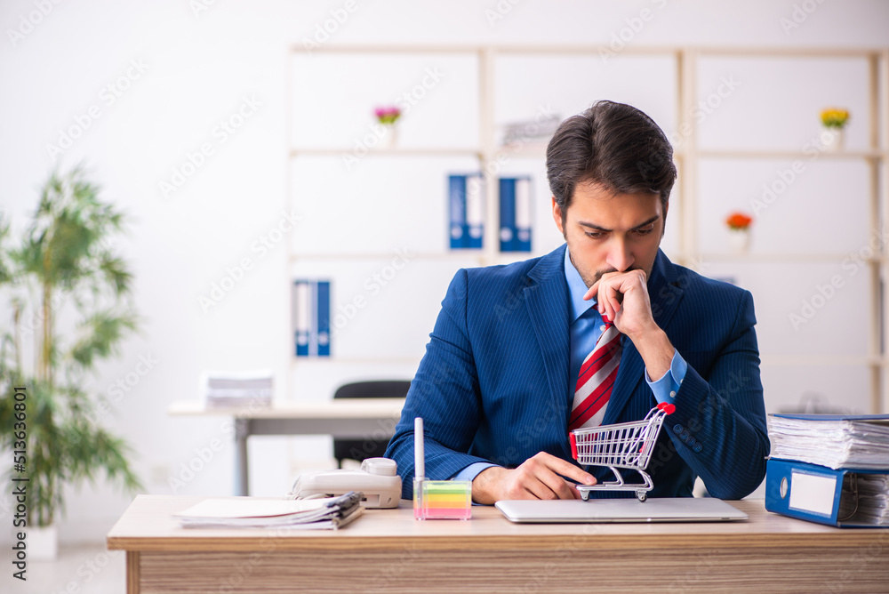 Young male employee in e-commerce concept Young male employee in e-commerce concept