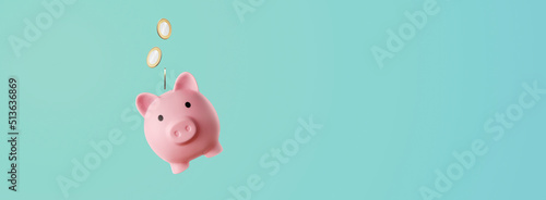 pink piggy bank with coins falling inside - savings concept photo