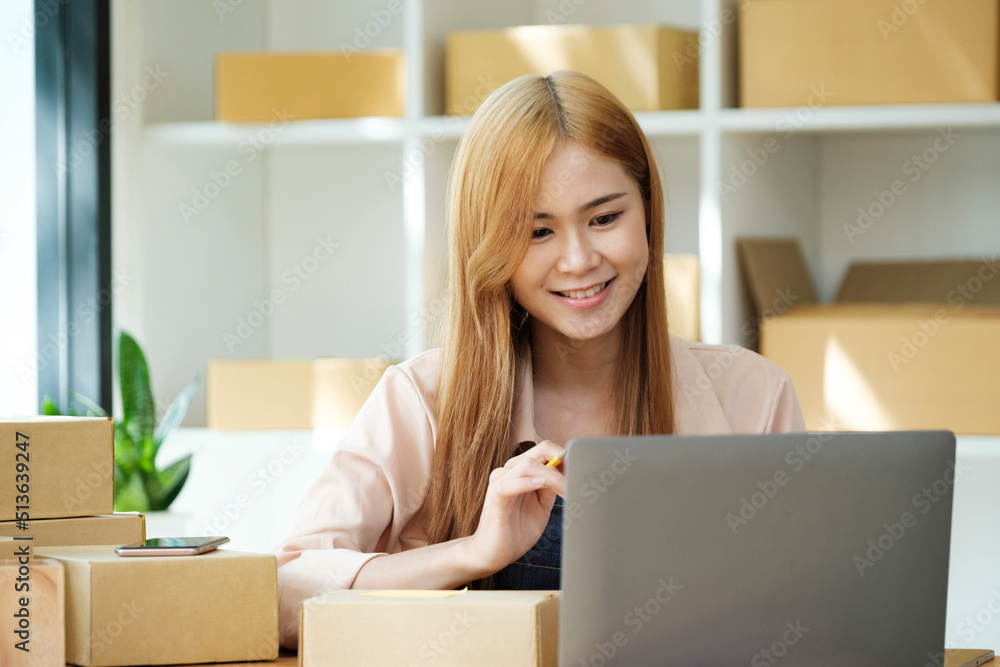 Online small business owner writing address on parcel box. Online small business owner writing address on parcel box.