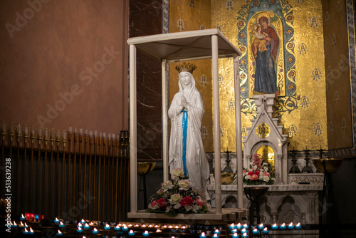 Fotografia Candles in front of Virgin Mary Altar at The Sanctuary of Our Lady of Lourdes