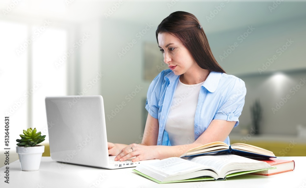 A woman looking annoyed and stressed, sitting at the desk, using a laptop, thinking, A woman looking annoyed and stressed, sitting at the desk, using a laptop, thinking,