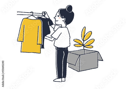 クローゼットに衣類をかける女性　転居や新築で、新しい家に荷物を運び入れる人々