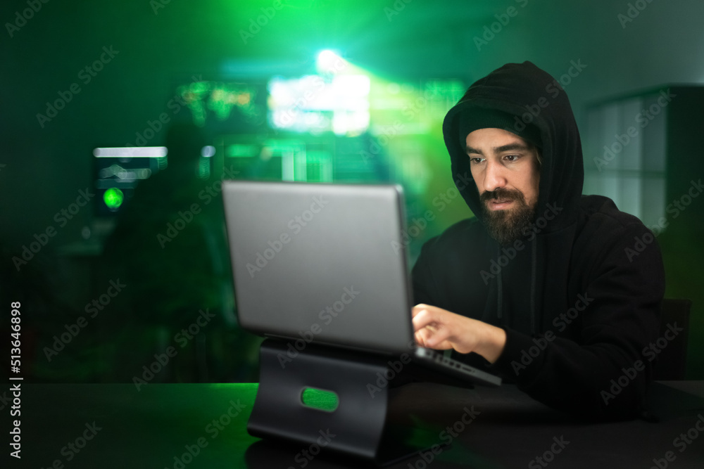 Male hacker using laptop typing bad data into computer online system. Copy space. Male hacker using laptop typing bad data into computer online system. Copy space.