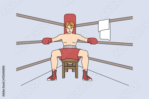 Male boxer sit in ring preparing for match