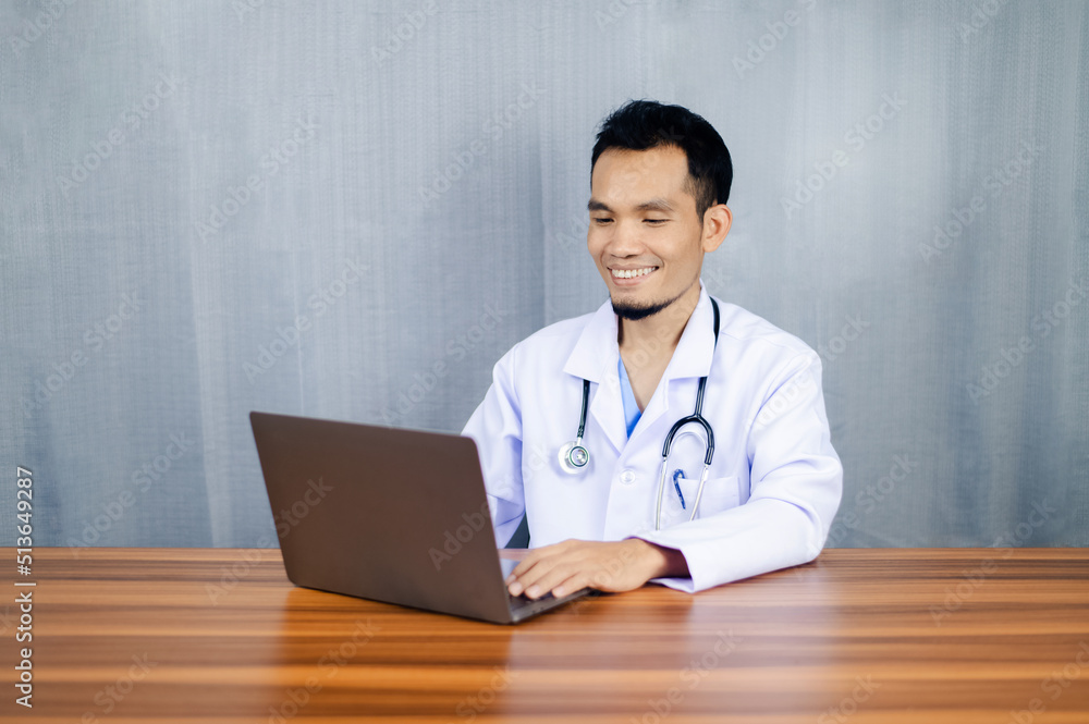 Asian doctor working laptop computer in office at hospital, doctor giving online consultation to his client online at clinic. Therapist talking to patient on web