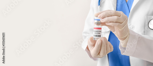 Female doctor with monkeypox vaccine on light background with space for text, closeup