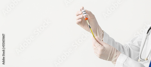 Doctor's hands with monkeypox vaccine and syringe on light background with space for text