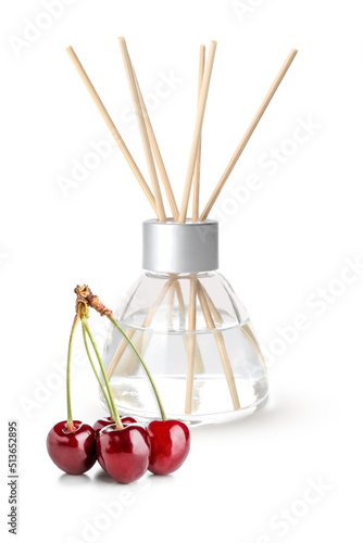 Reed diffuser and cherry on white background