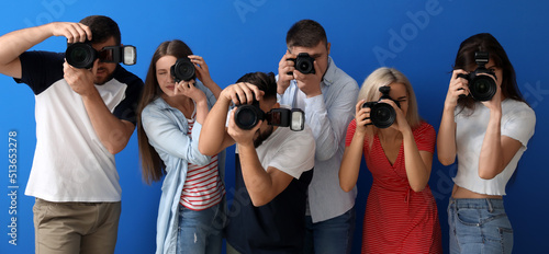 Group of young photographers on blue background
