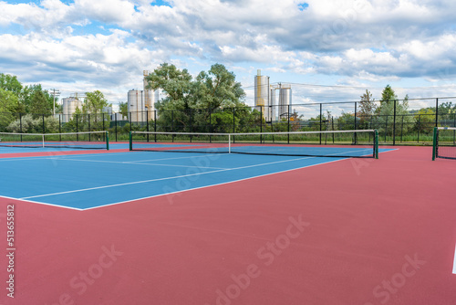 New blue tennis courts with white lines and red out of play area. 
