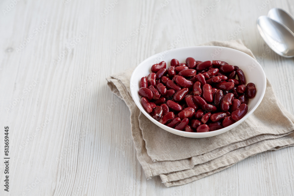 Red Organic Kidney Beans in a White Bowl on a white wooden background, side view. Copy space. Red Organic Kidney Beans in a White Bowl on a white wooden background, side view. Copy space.