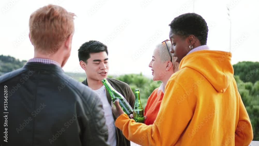 multiethnic young fiends drinking beer talking and laughing in a rooftop multiethnic young fiends drinking beer talking and laughing in a rooftop