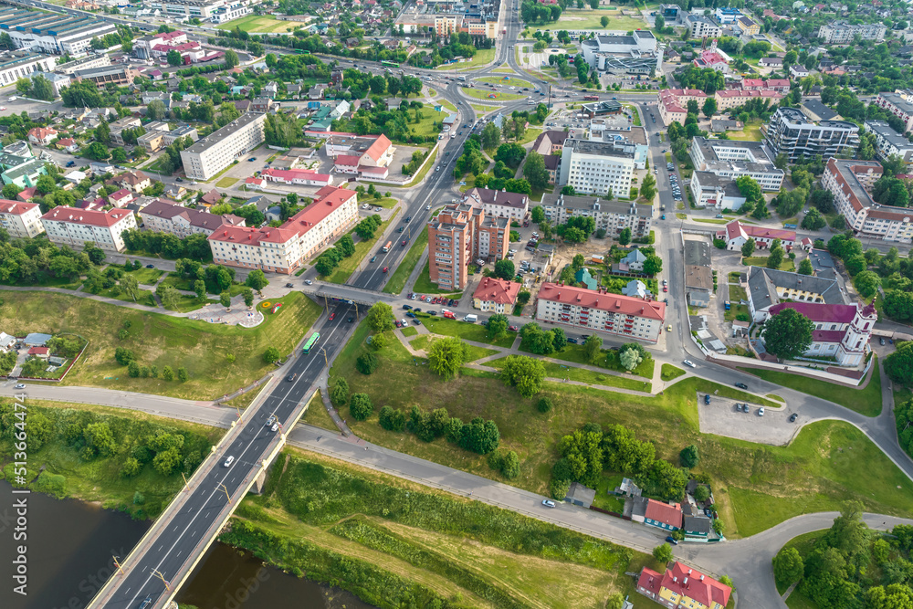 aerial view from great height on red roofs of old city with heavy traffic on bridge with wide multi-lane road across wide river aerial view from great height on red roofs of old city with heavy traffic on bridge with wide multi-lane road across wide river