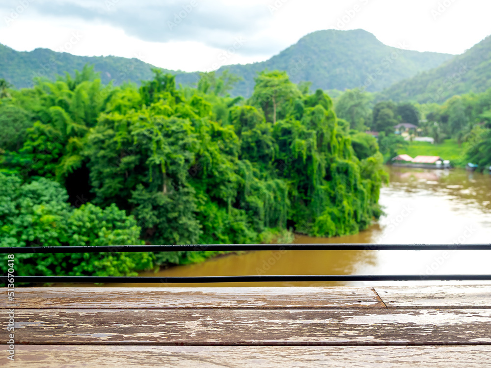 Empty space on old wooden plank table bar on river wild, green tropical forest and. mountain view. Blank space for product display mockup advertising in front of green idyllic blurred water nature. Empty space on old wooden plank table bar on river wild, green tropical forest and. mountain view. Blank space for product display mockup advertising in front of green idyllic blurred water nature.