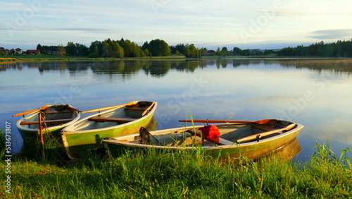 3 Angelboote liegen malerisch auf dem Bad Soier See im Morgenlicht am Ufer des spiegelnden Sees