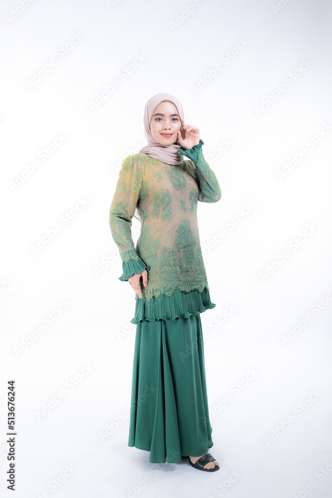 Beautiful female model in poses wearing traditional apparel and hijab, an urban lifestyle look for Muslim women isolated on white background. Beauty and hijab fashion concept. Full length Beautiful female model in poses wearing traditional apparel and hijab, an urban lifestyle look for Muslim women isolated on white background. Beauty and hijab fashion concept. Full length