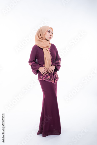 Beautiful female model in poses wearing traditional apparel and hijab, an urban lifestyle look for Muslim women isolated on white background. Beauty and hijab fashion concept. Full length