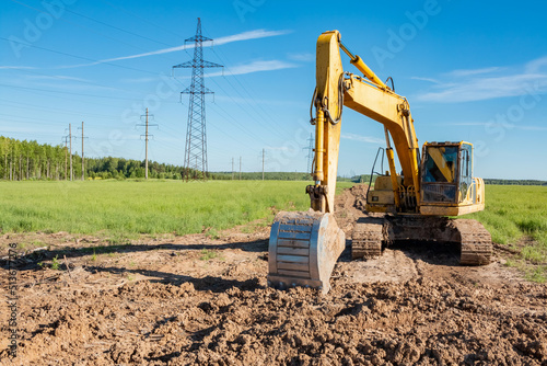 Excavator on the background of power lines.