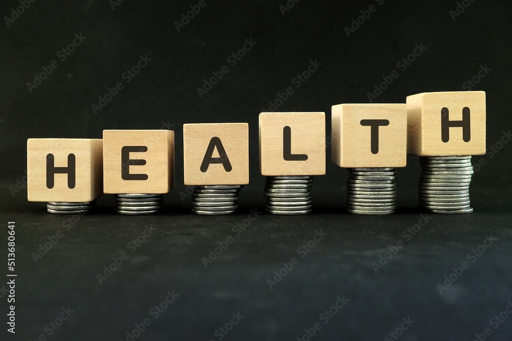 Obraz premium Expensive or high cost of healthcare and saving and investing for health concept. Increasing stack of coins in dark black background.