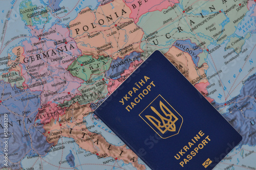 Ukrainian international passport and world map refugee concept . High quality photo