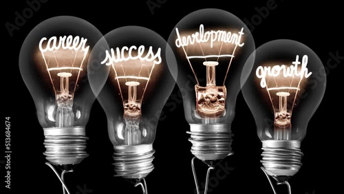 Light bulbs going from dark to light with Career, Success, Development and Growth fiber text on black background. High quality 4k video.
