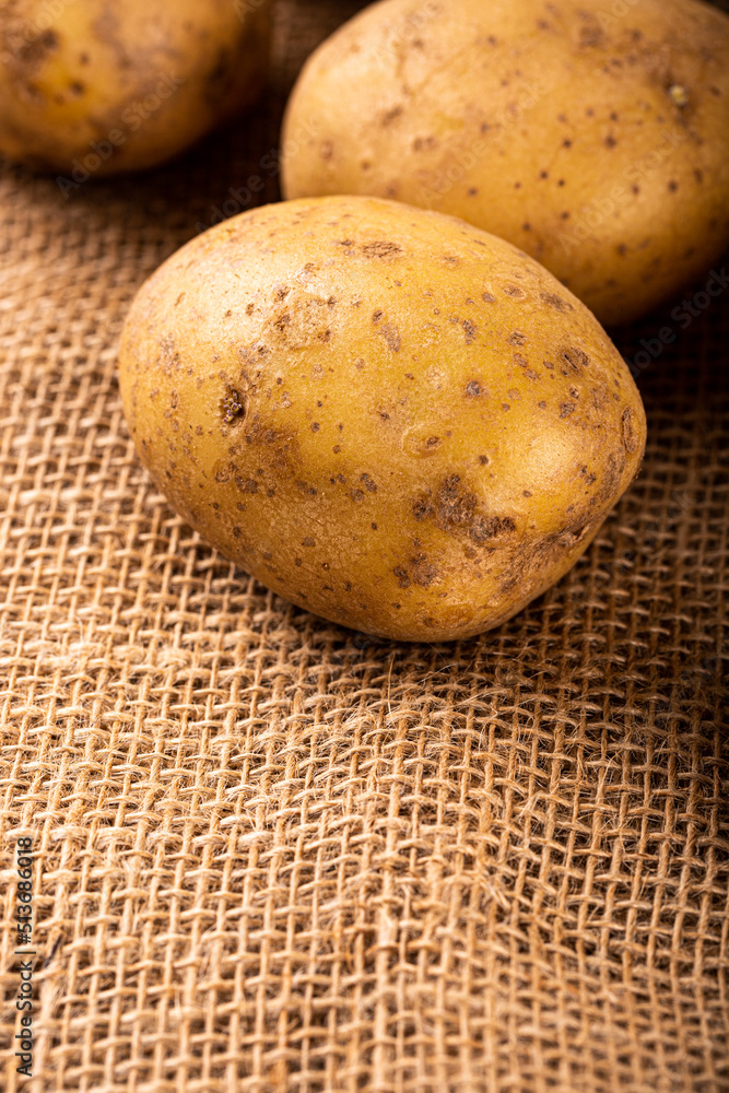 Raw whole washed organic white potatoes on sackcloth. Healthy vegetarian food concept with copy space Raw whole washed organic white potatoes on sackcloth. Healthy vegetarian food concept with copy space