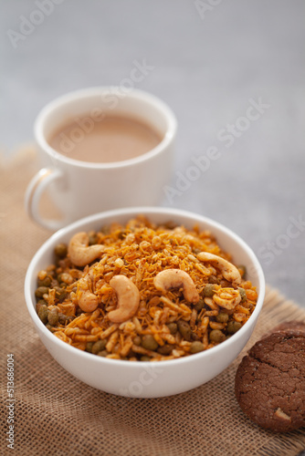 Close-Up of crunchy Indian mixture snacks with hot tea or Coffee time and handmade cookies (biscuits). Studio shoot at declined angle.