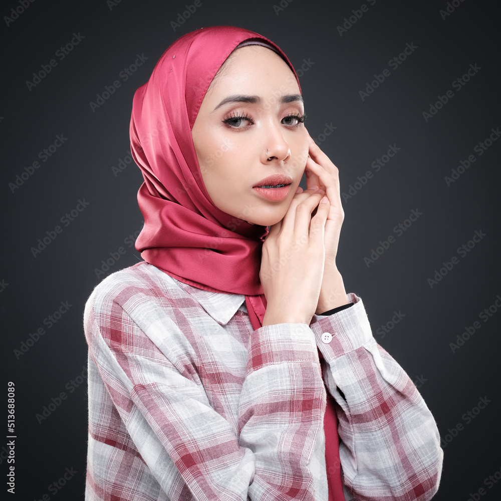 Half height portrait of a beautiful female model wearing traditional dress and hijab, a lifestyle apparel for Muslim women isolated on grey background. Idul Fitri and hijab fashion concept. Half height portrait of a beautiful female model wearing traditional dress and hijab, a lifestyle apparel for Muslim women isolated on grey background. Idul Fitri and hijab fashion concept.