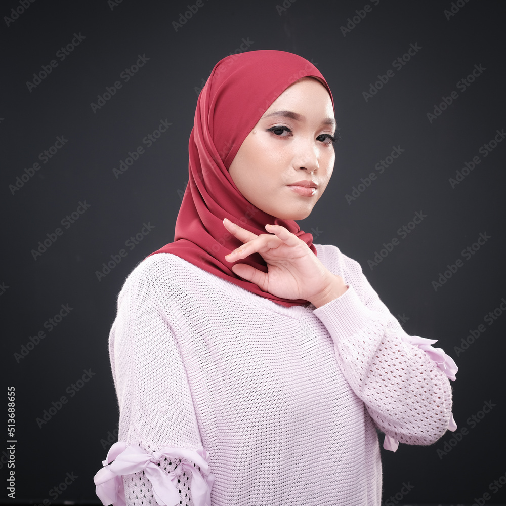Half height portrait of a beautiful female model wearing traditional dress and hijab, a lifestyle apparel for Muslim women isolated on grey background. Idul Fitri and hijab fashion concept. Half height portrait of a beautiful female model wearing traditional dress and hijab, a lifestyle apparel for Muslim women isolated on grey background. Idul Fitri and hijab fashion concept.