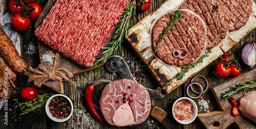 Raw meat products, different parts of the body. minced beef meat kebabs, pork, beef, chicken on a wooden background. Long banner format. top view