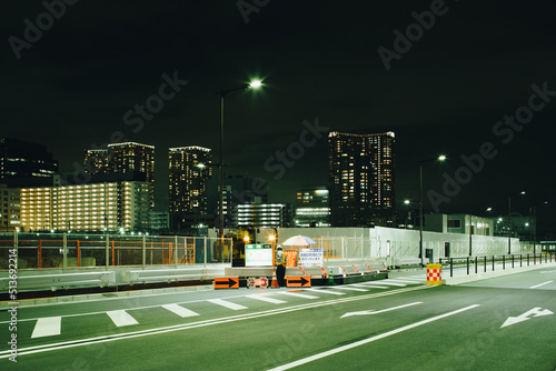 深夜の道路の工事現場で交通整理の仕事をする警備員の風景 photo