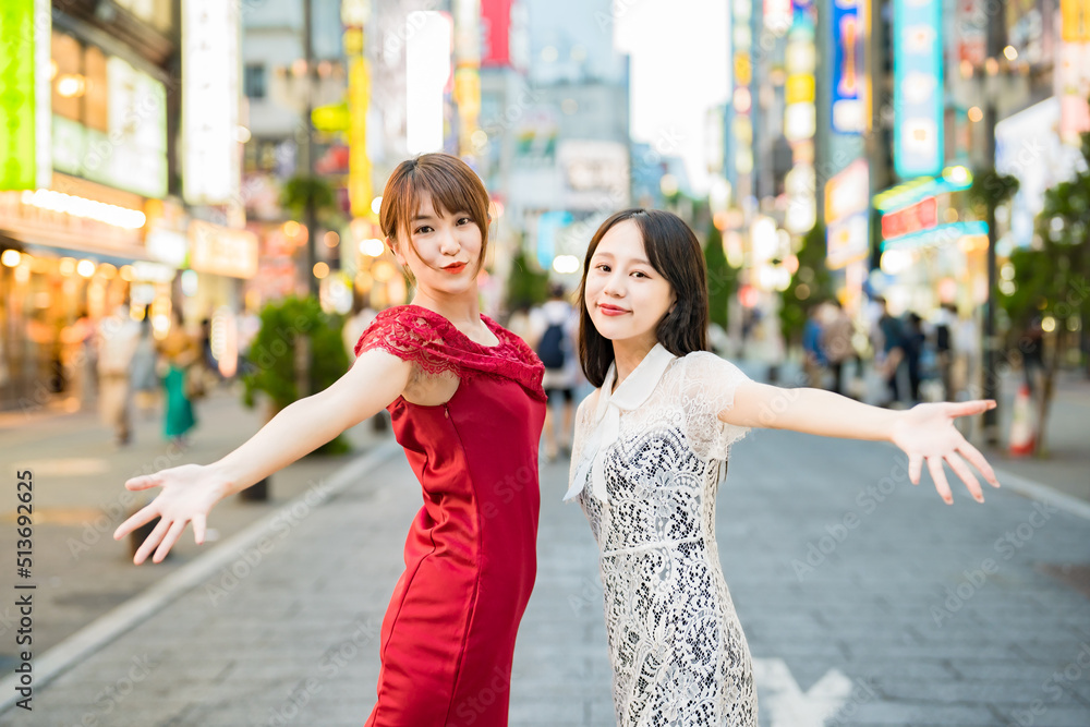 Fototapeta premium 繁華街でポーズをとる女性2人